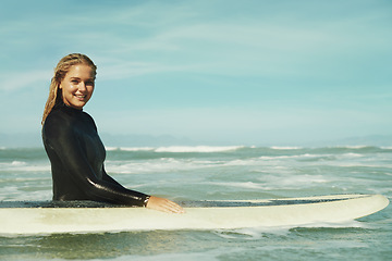 Image showing Portrait, smile and woman with surfboard in ocean for sports, vacation or holiday in summer. Sky, sea and waves with happy young surfer person in wetsuit for travel, fitness or exercise in nature