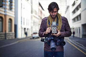 Image showing Vintage, camera and photographer in city for photoshoot with professional gear to film on street. Travel, photography and creative cameraman with retro lens to capture urban media outdoor on road