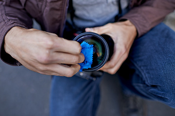 Image showing Clean, camera and lens in hands of photographer to prepare equipment for photoshoot and process. Cameraman, closeup and wipe gear to start photography outdoor with care for professional technology