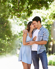 Image showing Couple, hug and happy in park with kiss in summer for partnership together or date, peaceful or embrace. Man, woman and bonding in nature backyard for relationship vacation or sun, holiday or trees