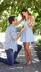 Image showing Man, woman and kneeling or proposal with engagement ring in park for question, happiness or jewellery. Couple, love and commitment or save the date in nature or wedding announcement, summer or garden