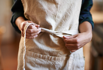 Image showing Hands, chef and tie apron in kitchen, restaurant or catering service at hotel for gastronomy. Closeup, cooking or person with knot on clothes, culinary uniform or preparation of professional waitress