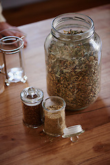 Image showing Jar, tea leaves and herbal plant on kitchen counter or health benefits or morning beverage, refreshing or wellness. Bottle, vitality and prepare as hot drinking or jasmine, hibiscus or stress relief