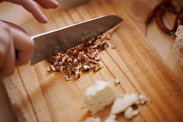 Image showing Knife, person chop nuts and cooking, salad and healthy food for diet, nutrition and wellness at home. Meal prep in kitchen, wood board and prepare dish for lunch or dinner with closeup of ingredients