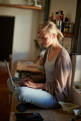 Image showing Woman, kitchen and laptop with technology, counter and connection for learning, internet or email. Influencer, and research for blog, payment or registration for planning, working or remote work