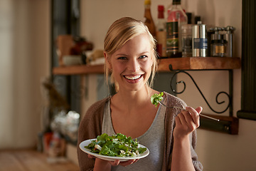 Image showing Portrait, happy woman and eating salad in kitchen at home, nutrition and leafy greens for healthy diet. Vegetables, bowl and face of hungry person with food, fork and organic vegan meal for wellness