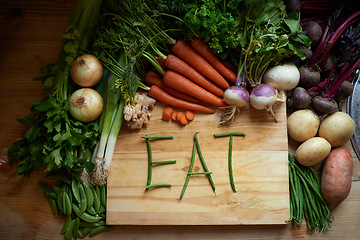 Image showing Food, chopping board and message for eating, wellness and cooking for wellbeing or hunger. Home, nutrition and vegetables for diet, health and vitamins in kitchen for vegan, vitality and still life