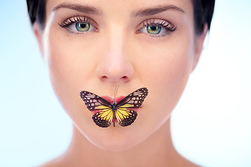 Image showing Portrait, beauty and butterfly with natural woman in studio on blue background for skincare or wellness. Spa, face or lips and confident young model looking confident with skin treatment routine