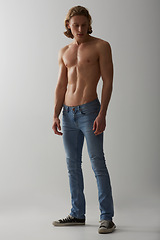 Image showing Shirtless, model and man in jeans on studio, white background and mockup with fashion. Male, beauty and handsome topless person with abs in denim pants, cool style and confidence in backdrop