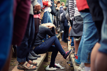 Image showing Woman, sad and alone in crowd while sitting outside at festival, protest or concert in Poland. Female supporter, exhausted or overwhelmed during outdoor fundraising event during spring or autumn