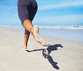 Image showing Person, running and feet at beach with exercise, sport and training for marathon by the sea. Workout, fitness and back of a athlete with health and wellness outdoor of runner with cardio in summer