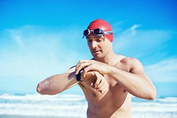 Image showing Sea, swimming and time of a man with a watch for heart rate, wellness and fitness app for sport. Beach, athlete and ocean with clock and timer for marathon or race training in summer outdoor