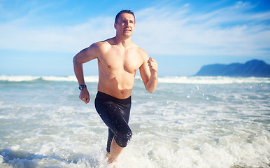 Image showing Man, running and water by a beach with fitness, sport and training for marathon by the sea. Workout, exercise and back of a athlete with health and wellness outdoor of runner with cardio in summer