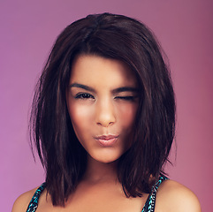 Image showing Studio, woman and makeup with wink, portrait and youth for beauty, model and individuality. Latino person, pink background and hairstyle for modern, hipster and cool with trendy, smile and confidence