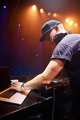 Image showing DJ, man and laptop at nightclub for concert with spotlights, turntables and live music show. Professional person with crowd, playlists and mixing deck for party, rave or festival in Portugal