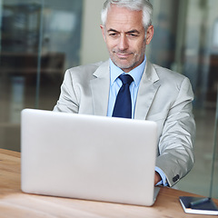 Image showing Senior, businessman and smile, laptop and research at desk in the office for consultant advice. CEO, man and plan for budget, management and human resources in company for startup proposal and diary