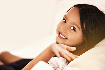 Image showing Happy, relax and portrait of child on couch for playful, fun and resting on weekend in living room. Smile, childhood and face of young girl alone on sofa for vacation, holiday and free time in home