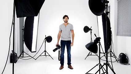 Image showing Photographer, portrait or lighting with equipment in studio for career, behind the scenes or camera. Photography, guy and confidence with electronics, flash or shooting gear for photoshoot or passion