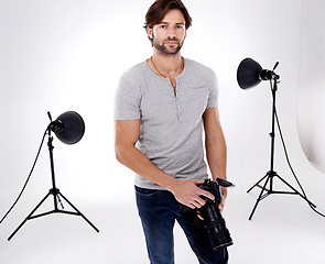 Image showing Photographer, confidence or lighting with equipment in studio for career, behind the scenes or camera. Photography, guy and portrait with electronics, flash or shooting gear for photoshoot or passion