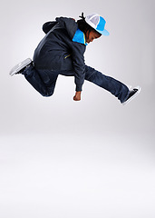 Image showing Child, jump and dancing with hiphop and street style clothing in a studio with boy dancer. Trendy, energy and cool African kid with youth and rap music with white background and gen z clothes