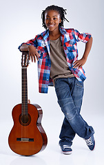 Image showing Music, studio and portrait of child with guitar and smile playing song isolated on white background. African boy, artist and creative kid in practice with acoustic instrument, inspiration or talent