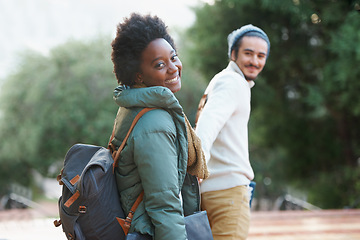 Image showing Walk, park and interracial couple together holding hands with smile, bag and morning commute to university. College, students and romance on campus, man and woman with diversity, love and nature.