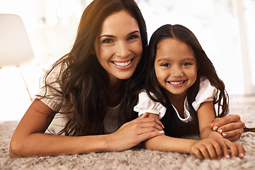 Image showing Happy mother, portrait and child hug in relax on floor for bonding, love or care together at home. Face of mom, parent and little girl, daughter or kid with smile in living room for family time