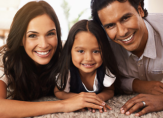 Image showing Happy family, portrait and hug with love for bonding, support or relax together at home. Face of mother, father and little girl, child or young kid with smile for embrace, holiday or weekend on floor