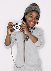 Image showing Photographer, portrait or happy kid in studio with camera isolated on white background for creative talent. Photography, African boy or child artist with hobby, smile or picture ready for photoshoot