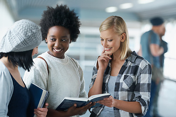 Image showing Students, women and reading in hallway at college with books for education, learning and knowledge. University, girl and friends with smile for break, relax and diversity with scholarship in corridor