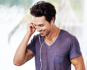 Image showing Man, smile and listening with earphones for music, mental health podcast or radio. Male person, happy and streaming online with headphones for audio with fun, wellness and enjoyment with confidence