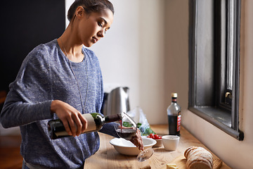 Image showing Woman, pour wine and home for dinner, relax for peace and leisure with drink in kitchen. Alcohol, glass and bottle with refreshment, hydration with beverage to celebrate or chill in apartment