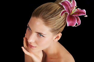 Image showing Hair care, flower and woman touch skin, thinking and beauty isolated on a black studio background. Natural, floral makeup and hand of model in cosmetics, salon and lily for organic facial treatment