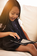 Image showing Little girl, child and tablet on sofa in entertainment, elearning or social media with lens flare at home. Face of female person or kid browsing on technology or reading ebook in living room at house