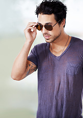 Image showing Fashion, sunglasses and man outdoor with confidence, cool style and pride in Miami. Summer, holiday and person with serious face in casual outfit for vacation in Florida and relax in sunshine