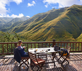 Image showing Woman, nature and eating on a balcony for holiday, vacation and travel destination at a countryside hotel or lodge. Person with breakfast, food and thinking of mountains or view on eco friendly patio