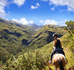 Image showing Woman, mountain and horse riding in nature for adventure, travel and journey with sustainability or tourism. Portrait of an equestrian or horseback rider on a hill for summer, holiday and vacation