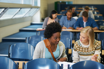 Image showing Discussion, university and women students in classroom with textbooks and documents for information. Smile, conversation and female friends talking and studying for college test, exam or assignment.