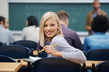 Image showing University student, portrait and smile at classroom desk in London for english lecture, education or scholarship. Female person, face and pen at academy with professor for teaching, lesson or exam