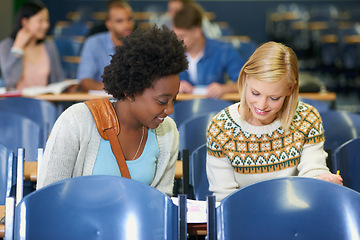 Image showing Conversation, university and women students in classroom with textbooks and documents for information. Smile, discussion and female friends talking and studying for college test, exam or assignment.