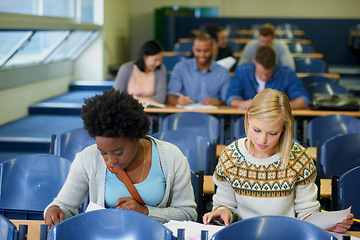 Image showing Studying, university and women students in classroom with textbooks and documents for information. Bonding, discussion and female friends talking and learning for college test, exam or assignment.