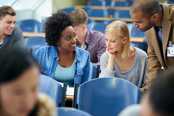 Image showing University student, teacher and classroom or test help in lecture hall or education, scholarship or learning. Female people, friends and professor or paperwork at college academy, teaching or London