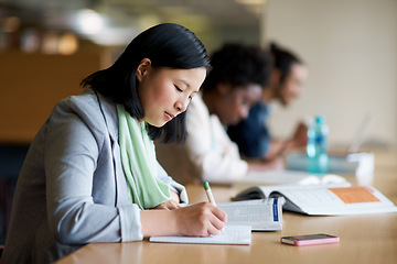 Image showing Student, library and studying with book at desk for university or education for future, exam or scholarship. Asian person, writing and reading for college degree in Korea for school, campus or test
