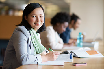 Image showing Student, portrait and library studying with book at desk for university or education for future, exam or scholarship. Asian person, writing and college degree in Korea for academic, campus or test