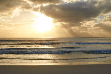 Image showing Sunset, beach or ocean water with clouds in summer, vacation or sunshine at background of horizon. Sea, waves or sand on land at twilight outdoor in nature, seashore or coastline to travel on holiday