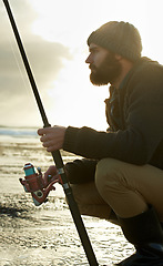 Image showing Beach, ocean and man with fishing rod in water in the morning in summer outdoor for hobby or leisure. Sea, fisherman and person with pole in nature, serious or angler thinking of recreation with reel