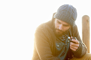 Image showing Young, man and smoking a pipe in outdoor, thinking and tobacco habit in morning by sunrise. English guy, nicotine addiction and retro smoker for calm, satisfaction and vacation by ocean in cape town