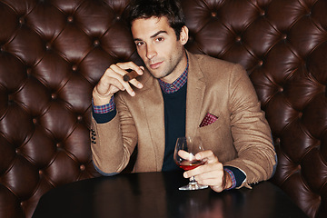 Image showing Portrait, cigar and businessman drinking at club, fashion and person in a suit with alcohol at vintage bar. Face, smoking and serious person with whiskey, scotch and brandy in glass for luxury at pub