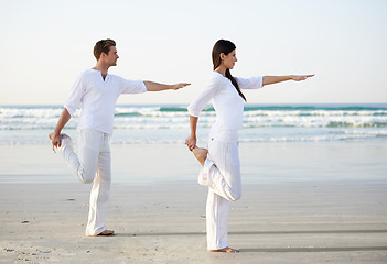 Image showing Couple, yoga and balance, fitness on beach for zen and wellness, travel and mindfulness with holistic healing. People outdoor, exercise and pose, workout together for bonding with ocean and nature