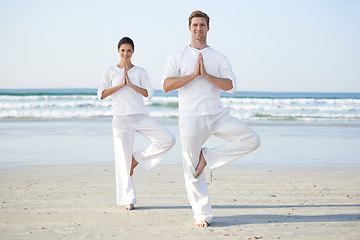 Image showing Balance, yoga and couple on beach in morning for fitness, exercise and workout in standing pose. Nature, pilates and man and woman by ocean for meditation, wellness and healthy body outdoors together